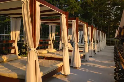 a row of wooden beds with curtains on them at SPA Hotel Infinity Park Velingrad in Velingrad