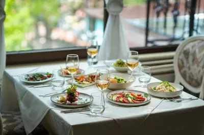 a table with plates of food and glasses of wine at Maxi Park Hotel & Spa in Velingrad