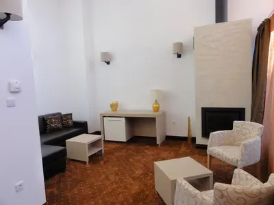 a living room with a couch and a chair at Radina's Way Hotel in Borovets