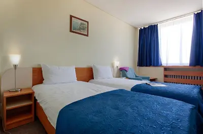 a hotel room with two beds with blue sheets at Hemus Hotel Sofia in Sofia