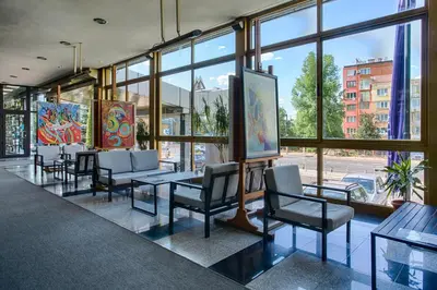 a restaurant with chairs and tables and windows at Hemus Hotel Sofia in Sofia