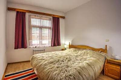 a bedroom with a large bed and a window at Hotel Kalina in Shiroka Lŭka