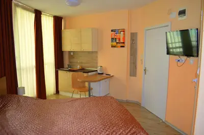 a bedroom with a bed and a table and a kitchen at Апарт Център Apart Center in Plovdiv