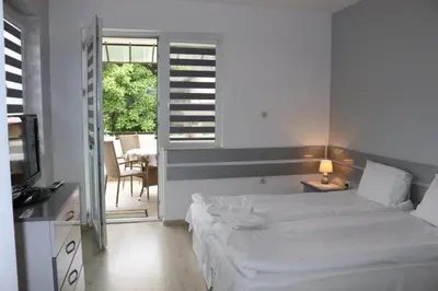 a bedroom with two beds and a television and a patio at Saint Maria Guest House in Velingrad