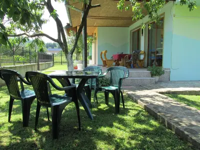 a table and chairs in front of a house at Pri Orehite Guesthouse in Oreshak