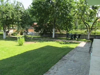 a lawn with a table and chairs in a park at Pri Orehite Guesthouse in Oreshak