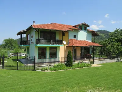 a house with a fence in front of a yard at Pri Orehite Guesthouse in Oreshak