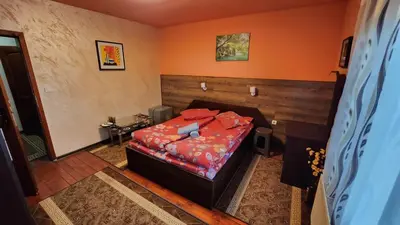 a bedroom with a bed in a room with orange walls at Guest House PIP in Velingrad