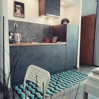 a kitchen with a sink and a chair in a room at Apartments 18 in Velingrad