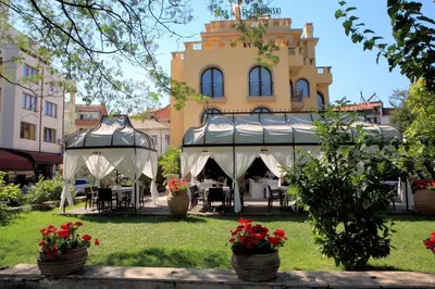 a garden with a gazebo in front of a building at Park Hotel Sandanski in Sandanski