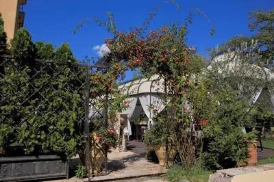 a garden with red flowers on a fence at Park Hotel Sandanski in Sandanski