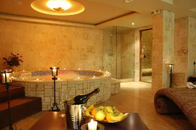 a bathroom with a tub and a bowl of fruit on a table at Park Hotel Sandanski in Sandanski