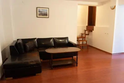 a living room with a black leather couch and a table at Villa Ibar in Borovets