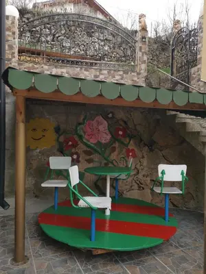 two chairs and a table in front of a wall at Guest House Milka in Yagodina
