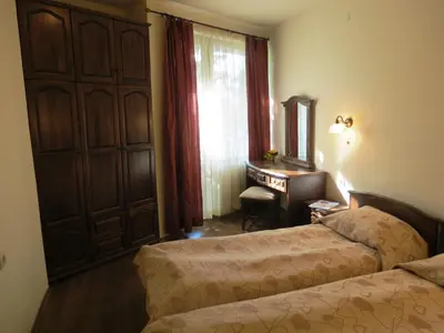 a bedroom with two beds and a desk and a window at Apartments & Studios Mountain Romance in Bansko
