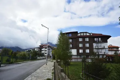 a street with a building on the side of a road at Apartments & Studios Mountain Romance in Bansko