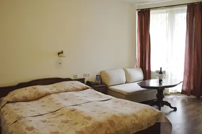 a bedroom with a bed and a table and a couch at Apartments & Studios Mountain Romance in Bansko