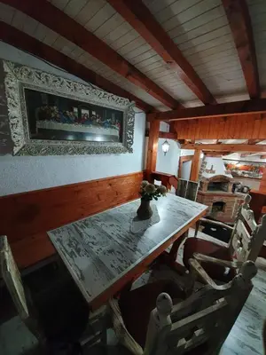 a dining room with a wooden table and chairs at Kashtata s Paraklisa in Borowo