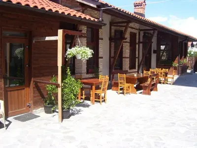 a patio of a house with a table and chairs at Apartments Four Leaf Clover Bansko to rent in Bansko