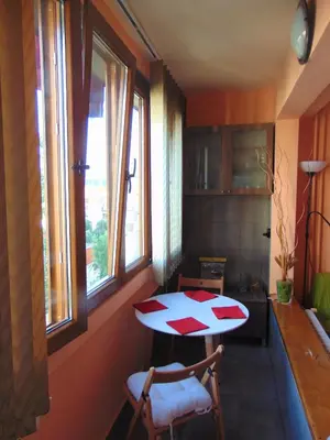 a kitchen with a table and two chairs and windows at Business Park Apartment in Sofia
