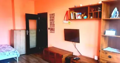 a living room with a television and a room with a bed at Business Park Apartment in Sofia