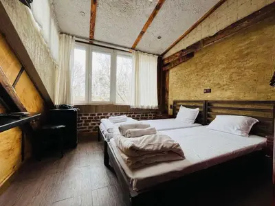 two beds in a large room with two windows at Rooms43 in Sofia