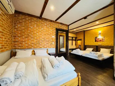 a bedroom with two beds and a brick wall at Rooms43 in Sofia