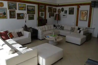 a living room with white couches and a table at EldoSport Hotel in Dospat