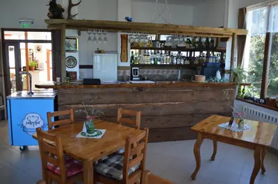 a restaurant with a wooden bar with a table and chairs at EldoSport Hotel in Dospat