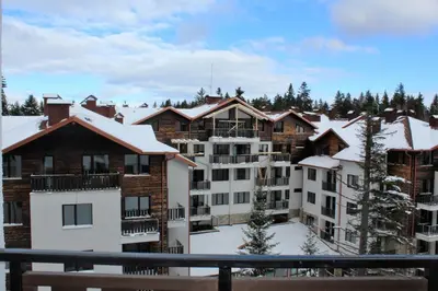 a group of buildings with snow on the roofs at Alpine luxury two bed-two bathrooms apartment B25 in Borovets