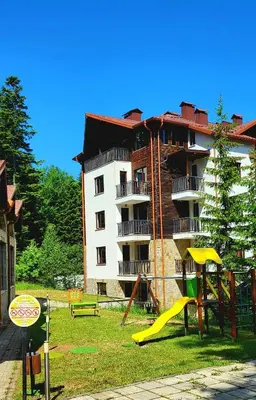 a apartment building with a playground in front of it at Alpine luxury two bed-two bathrooms apartment B25 in Borovets