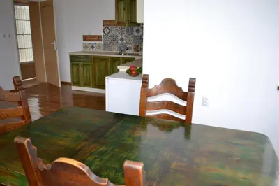 a kitchen with a wooden table with chairs and a tableablish at Vila Venera in Velingrad