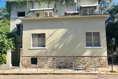a white building with barred windows on a street at The Bookies Apartments in Sofia