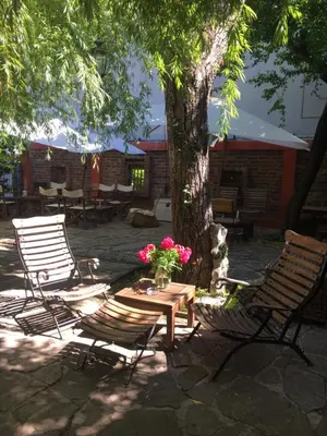 two chairs and a table under a tree with flowers at The Bookies Apartments in Sofia