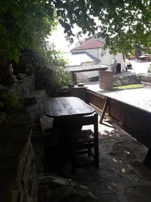 a wooden table and a bench in a yard at Kyshta za Gosti Gospodevi in Gorno Dryanovo