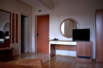 a living room with a television on a desk with a mirror at Hotel Jeravna in Bankya