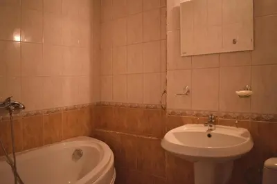 a bathroom with a sink and a toilet and a tub at Hotel Jeravna in Bankya