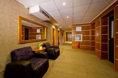 a waiting room with chairs and a table in a building at Spa Hotel Spartak in Sandanski
