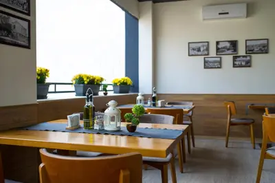 a dining room with wooden tables and chairs at Spa Hotel Spartak in Sandanski