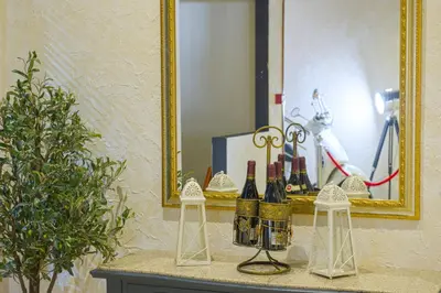 a table with bottles of wine and a mirror at Spa Hotel Spartak in Sandanski