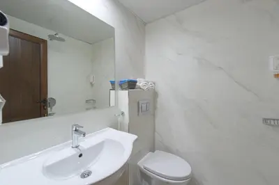 a bathroom with a sink and a toilet and a mirror at Spa Hotel Spartak in Sandanski