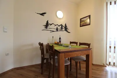 a dining room with a table with chairs and birds on the wall at Pine Tree Apartment D34 in Bansko
