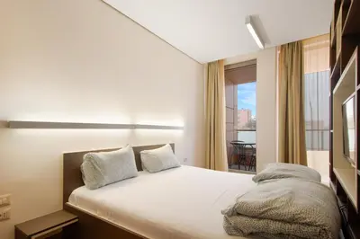 a bedroom with a bed and a large window at Deluxe Studio Studentski Grad in Sofia