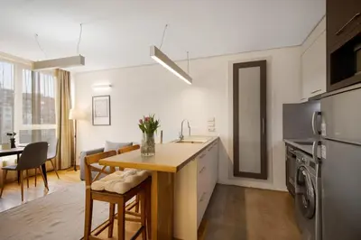a kitchen with a sink and a table with chairs at Deluxe Studio Studentski Grad in Sofia