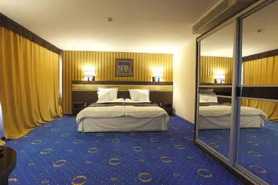 a hotel room with two beds and a mirror at Grand Hotel Hebar in Pazardzhik
