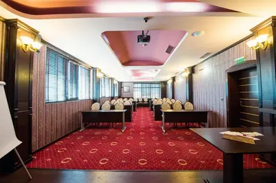 a waiting room with chairs and tables on a red carpet at Grand Hotel Hebar in Pazardzhik