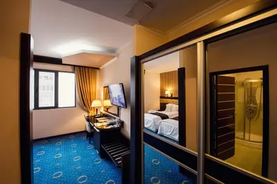 a hotel room with a bed and a desk and a mirror at Grand Hotel Hebar in Pazardzhik