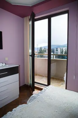 a bedroom with a bed and a view of a balcony at Apartment Ira in Velingrad