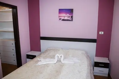 a bedroom with a bed with two white shoes on it at Apartment Ira in Velingrad