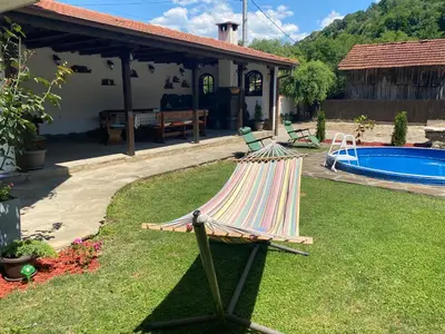 a hammock in a yard next to a pool at Yovkovata Kyshta in Chiflik